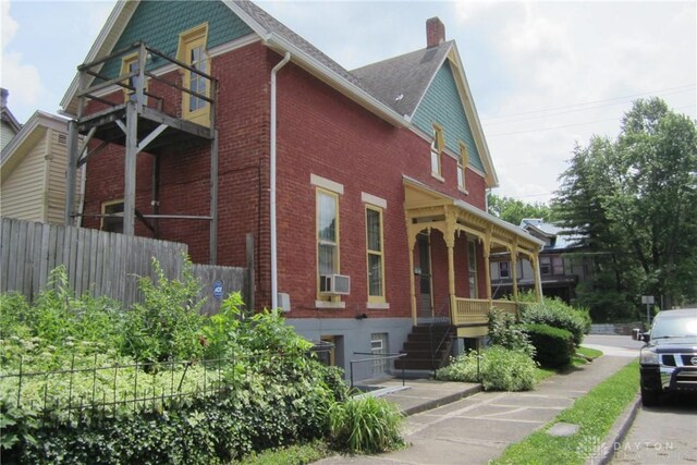 1600 Wayne Ave, Dayton, OH 45410 - view of side of property featuring brick siding, a porch, a chimney, stairs, and cooling unit