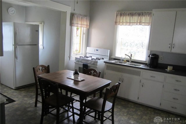 1600 Wayne Ave, Dayton, OH 45410 - kitchen featuring white appliances, dark flooring, white cabinetry, and dark countertops