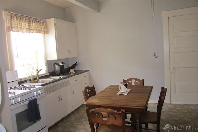 1600 Wayne Ave, Dayton, OH 45410 - kitchen with white gas stove, white cabinets, and dark countertops