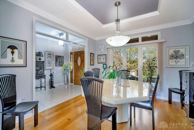 1668 Nichole Ct, Hamilton, OH 45013 - dining space with a tray ceiling, baseboards, light wood-style floors, crown molding, and a textured ceiling