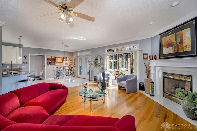 1668 Nichole Ct, Hamilton, OH 45013 - living area with a textured ceiling, crown molding, ceiling fan, a fireplace with flush hearth, and wood finished floors