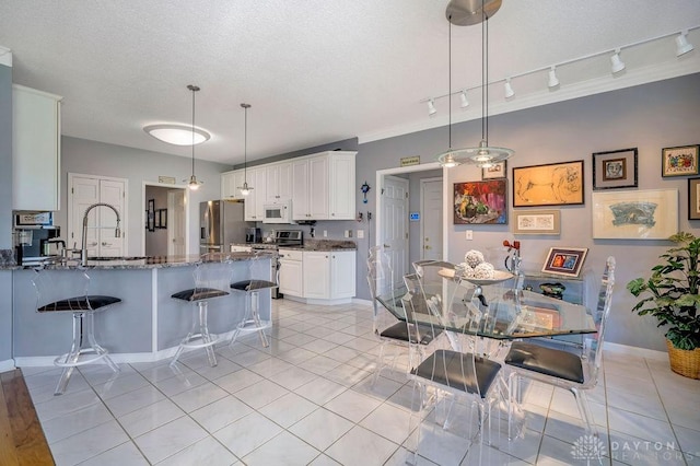 1668 Nichole Ct, Hamilton, OH 45013 - dining room with track lighting, light tile patterned floors, baseboards, and a textured ceiling