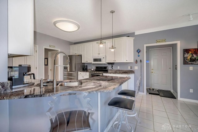 1668 Nichole Ct, Hamilton, OH 45013 - kitchen with appliances with stainless steel finishes, a peninsula, a kitchen breakfast bar, dark stone countertops, and baseboards