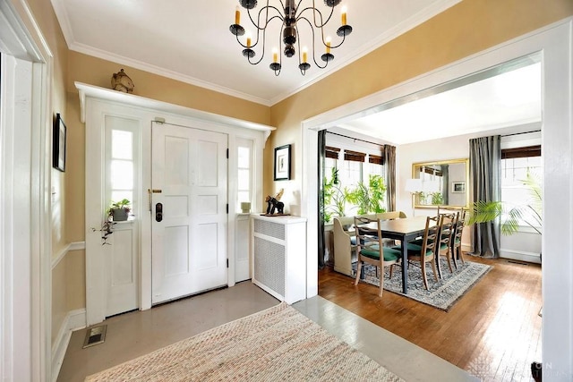 435 Marcia Ave, Hamilton, OH 45013 - foyer featuring plenty of natural light, a chandelier, crown molding, wood finished floors, and baseboards