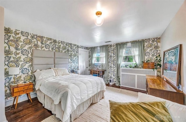 435 Marcia Ave, Hamilton, OH 45013 - bedroom featuring wallpapered walls, wood finished floors, radiator heating unit, and baseboards