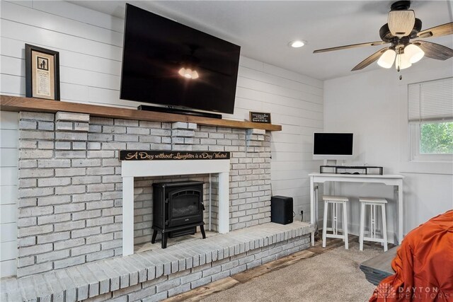 559 Stover Rd, West Alexandria, OH 45381 - carpeted living area with a ceiling fan, wooden walls, a wood stove, and recessed lighting