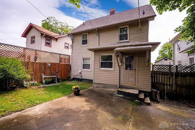 2057 Rugby Rd, Dayton, OH 45406 - back of property featuring a fenced backyard, a chimney, a patio, and roof with shingles