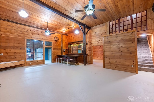 9891 Sugar St, Germantown, OH 45327 - living area featuring wood walls, ceiling fan, finished concrete flooring, wooden ceiling, and stairs