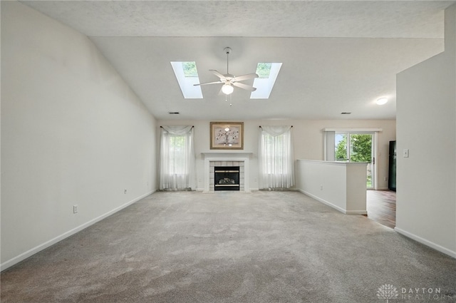 5555 Stone Path Dr, Middletown, OH 45042 - unfurnished living room featuring carpet, lofted ceiling, baseboards, a tile fireplace, and a skylight