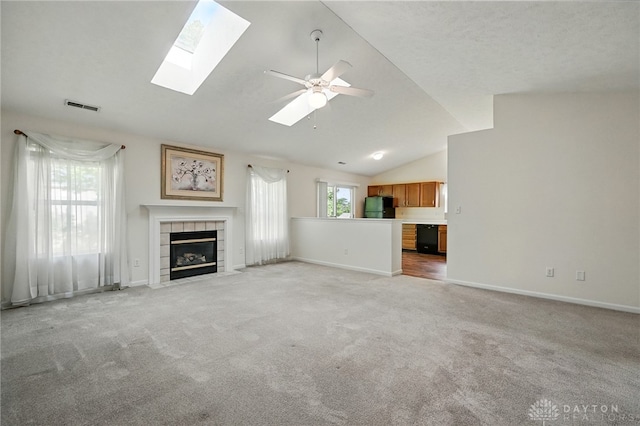 5555 Stone Path Dr, Middletown, OH 45042 - unfurnished living room featuring a tile fireplace, light carpet, vaulted ceiling, and baseboards