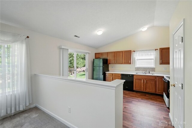 5555 Stone Path Dr, Middletown, OH 45042 - kitchen with black appliances, a sink, brown cabinetry, vaulted ceiling, and a peninsula