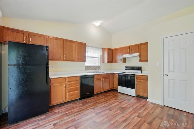 5555 Stone Path Dr, Middletown, OH 45042 - kitchen with black appliances, under cabinet range hood, light countertops, light wood-type flooring, and high vaulted ceiling