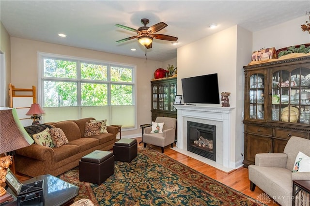 2082 Tamarack Ridge Ct, Beavercreek, OH 45431 - living room featuring wood finished floors, ceiling fan, a fireplace with flush hearth, recessed lighting, and baseboards