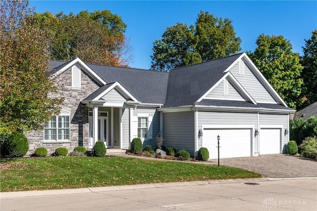 2082 Tamarack Ridge Ct, Beavercreek, OH 45431 - view of front facade featuring a garage, driveway, a front lawn, stone siding, and roof with shingles