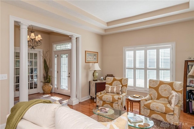 2082 Tamarack Ridge Ct, Beavercreek, OH 45431 - living area with ornate columns, wood finished floors, a chandelier, and baseboards