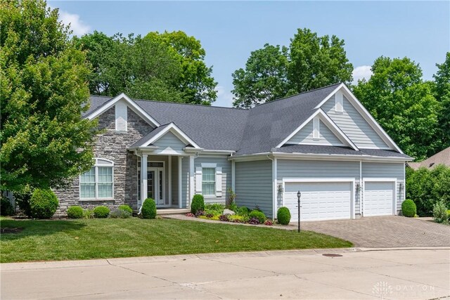 2082 Tamarack Ridge Ct, Beavercreek, OH 45431 - view of front of home featuring driveway, an attached garage, a front yard, stone siding, and a shingled roof