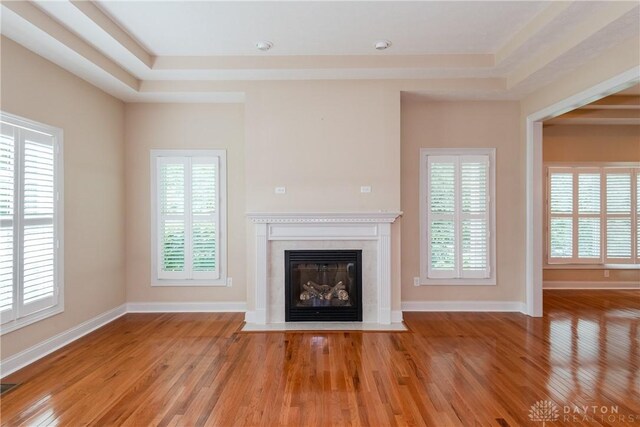 2082 Tamarack Ridge Ct, Beavercreek, OH 45431 - unfurnished living room featuring a fireplace with flush hearth, wood finished floors, healthy amount of natural light, and a tray ceiling