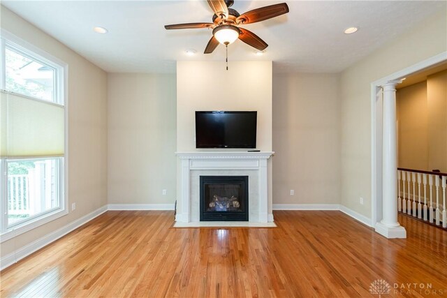 2082 Tamarack Ridge Ct, Beavercreek, OH 45431 - unfurnished living room with wood finished floors, a fireplace with flush hearth, a ceiling fan, decorative columns, and recessed lighting