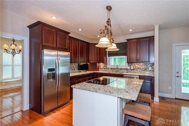 2082 Tamarack Ridge Ct, Beavercreek, OH 45431 - kitchen featuring stainless steel appliances, light wood finished floors, tasteful backsplash, a center island, and recessed lighting