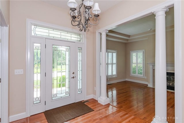 2082 Tamarack Ridge Ct, Beavercreek, OH 45431 - entryway featuring decorative columns, a chandelier, healthy amount of natural light, and light wood-style flooring