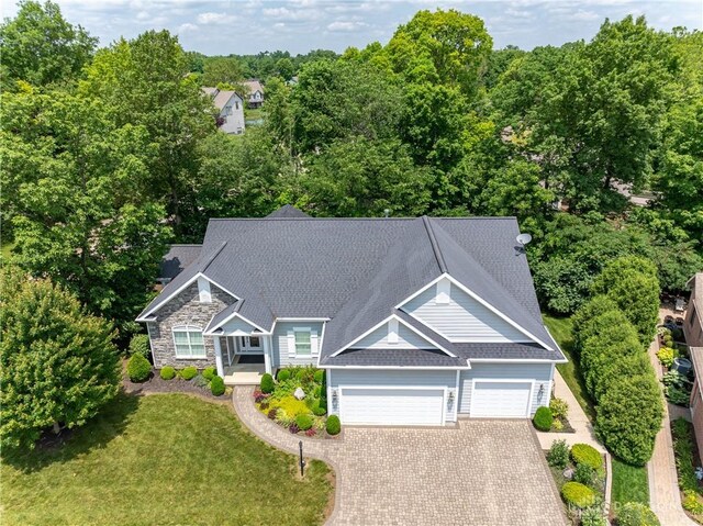 2082 Tamarack Ridge Ct, Beavercreek, OH 45431 - view of front facade featuring a garage, driveway, a front lawn, stone siding, and a shingled roof