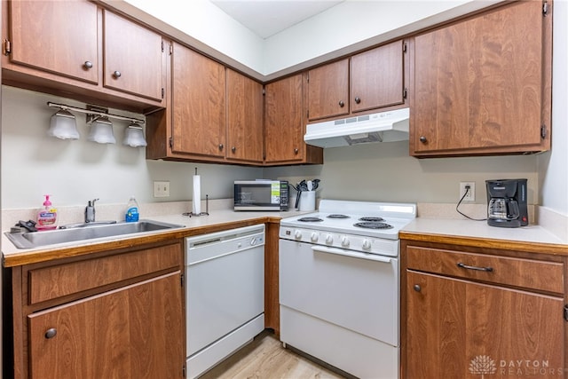 2225 Coach Dr Unit 29A, Kettering, OH 45440 - kitchen featuring white appliances, under cabinet range hood, a sink, light countertops, and light wood-type flooring