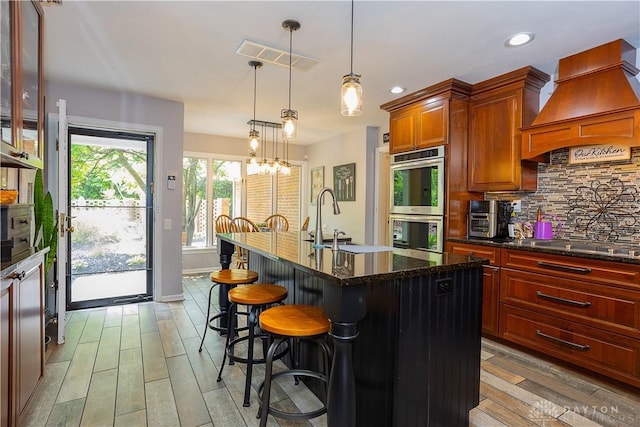 446 Lookout Rdg, Oakwood, OH 45419 - kitchen featuring stainless steel appliances, custom range hood, light wood finished floors, backsplash, and a sink