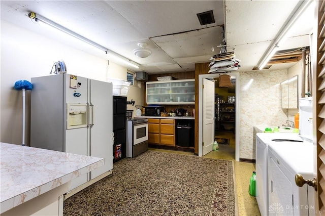 446 Lookout Rdg, Oakwood, OH 45419 - kitchen featuring washer and clothes dryer, stainless steel electric range oven, light countertops, and white refrigerator with ice dispenser