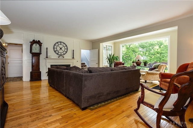 446 Lookout Rdg, Oakwood, OH 45419 - living room with a fireplace, light wood finished floors, crown molding, a decorative wall, and stairs