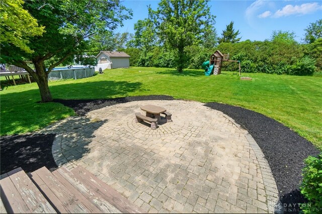 5193 Horseshoe Dr, Lewisburg, OH 45338 - view of patio with an outdoor fire pit, a playground, and an outdoor pool