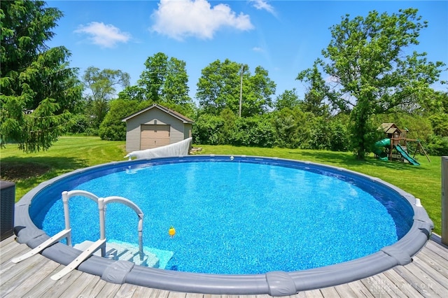 5193 Horseshoe Dr, Lewisburg, OH 45338 - outdoor pool with a yard, an outbuilding, a playground, and view of scattered trees