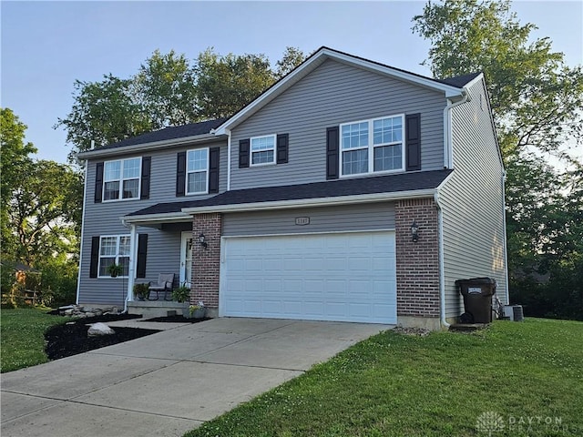 1147 Spegele Ct, Xenia, OH 45385 - view of front facade with an attached garage, a front yard, driveway, and brick siding