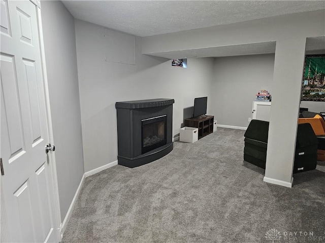 1147 Spegele Ct, Xenia, OH 45385 - finished basement with carpet floors, baseboards, a textured ceiling, and a glass covered fireplace