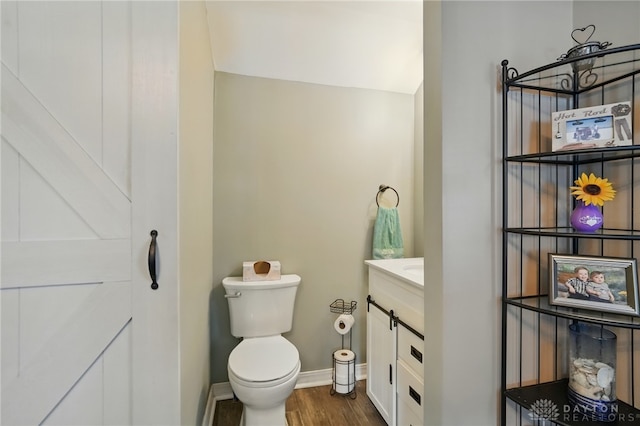 646 Barnhart Rd, Troy, OH 45373 - bathroom with vanity, toilet, wood finished floors, and baseboards