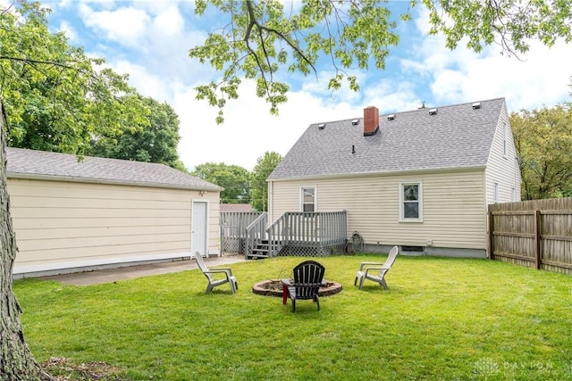 224 Locust Ln, West Milton, OH 45383 - back of property with a fire pit, a wooden deck, a shingled roof, and a chimney