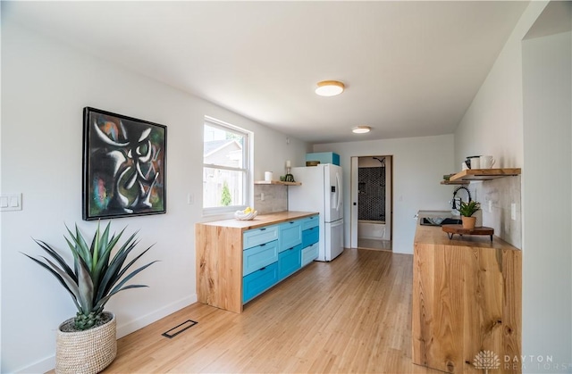 165 Mcreynolds St, Dayton, OH 45403 - kitchen featuring open shelves, white fridge with ice dispenser, butcher block countertops, and blue cabinetry