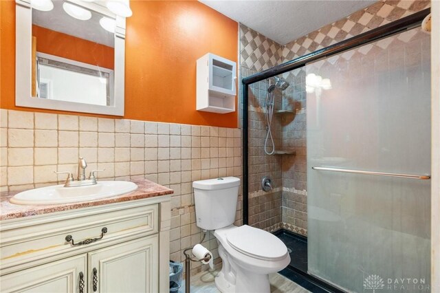 4278 Crownwood Ave, Dayton, OH 45415 - bathroom featuring tile walls, a shower stall, vanity, and wainscoting
