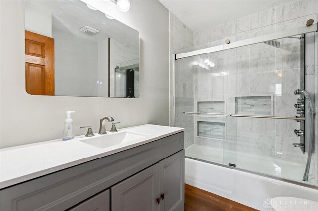 4278 Crownwood Ave, Dayton, OH 45415 - full bathroom featuring vanity, bath / shower combo with glass door, and wood finished floors