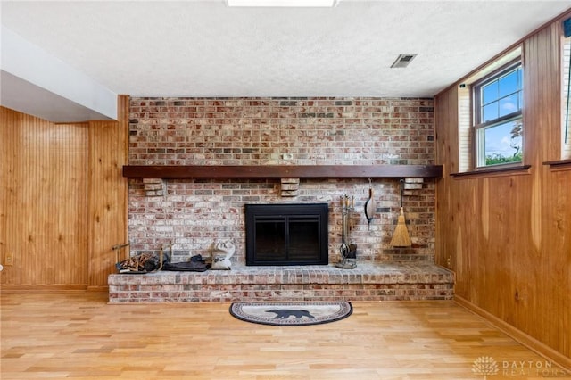 4278 Crownwood Ave, Dayton, OH 45415 - detailed view of wood finished floors, wooden walls, a fireplace, and a textured ceiling