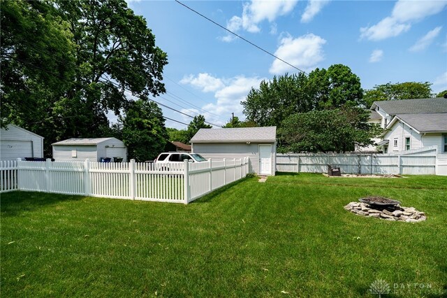 2231 King Ave, Dayton, OH 45420 - fenced yard with a fire pit, a garage, and an outbuilding