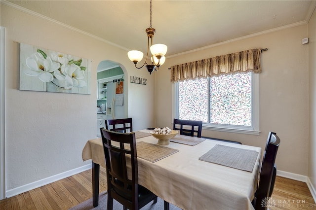 2231 King Ave, Dayton, OH 45420 - dining room featuring arched walkways, wood finished floors, crown molding, and a chandelier