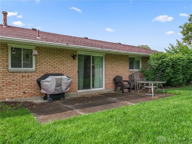 2378 E Rahn Rd, Kettering, OH 45440 - back of property with brick siding, a yard, a patio, and a shingled roof