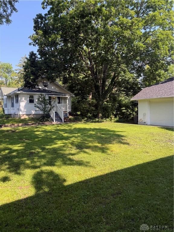 114 N Clayton Rd, New Lebanon, OH 45345 - view of green lawn with a garage