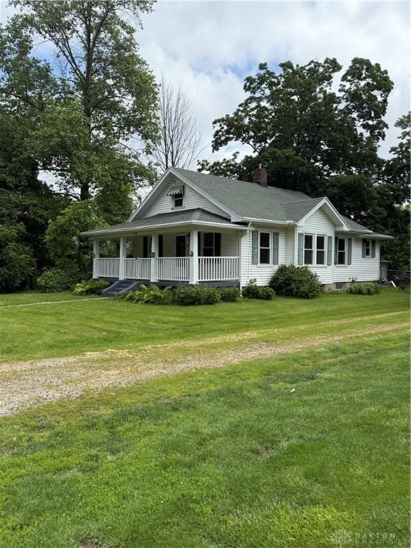 114 N Clayton Rd, New Lebanon, OH 45345 - view of front of house featuring a porch, a front yard, and a chimney