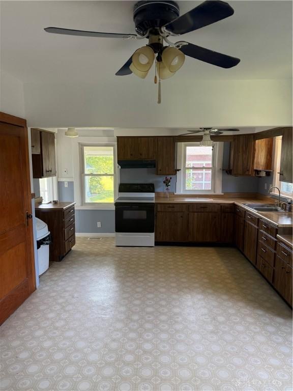 114 N Clayton Rd, New Lebanon, OH 45345 - kitchen featuring range with electric cooktop, under cabinet range hood, light floors, ceiling fan, and plenty of natural light