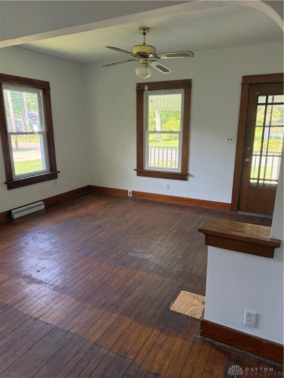 114 N Clayton Rd, New Lebanon, OH 45345 - unfurnished room featuring a baseboard radiator, healthy amount of natural light, and dark wood-style flooring
