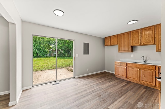 1927 Vermont Dr, Xenia, OH 45385 - kitchen with light wood-type flooring, brown cabinetry, electric panel, and light countertops