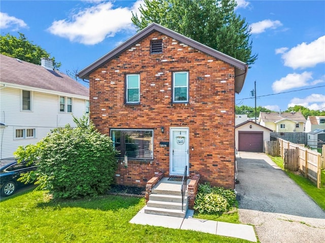 1707 Maiden Ln, Springfield, OH 45504 - view of front of home with brick siding, asphalt driveway, a detached garage, and an outbuilding