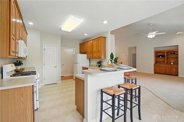 3862 Robinson Vail Rd, Franklin, OH 45005 - kitchen with white appliances, a breakfast bar, open floor plan, a peninsula, and a ceiling fan