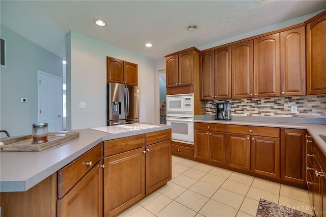 3334 Greycliff Trl, Franklin Twp, OH 45005 - kitchen featuring white appliances, light tile patterned floors, tasteful backsplash, brown cabinets, and recessed lighting